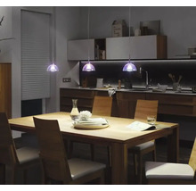 Matbord med stolar och pendellampor i modern köksdesign.