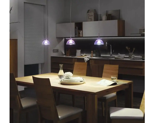 Matbord med stolar och pendellampor i modern köksdesign.