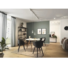 Ljust vardagsrum med matbord, stolar, hyllsystem och belysning