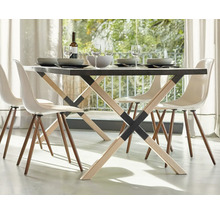 Matbord med fyra stolar, porslin och drycker i ett ljust rum.