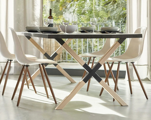 Matbord med fyra stolar, porslin och drycker i ett ljust rum.