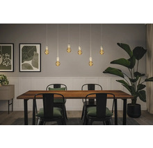 Matsal med träbord, stolar och pendellampor med glödlampor