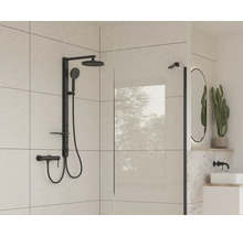 Modernt badrum med svart duschblandare och glasvägg.