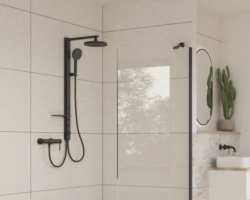 Modernt badrum med svart duschblandare och glasvägg.
