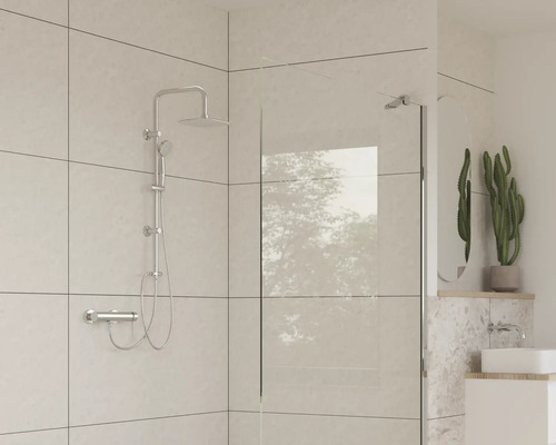 Badrum med duscharmatur, duschvägg och handfat