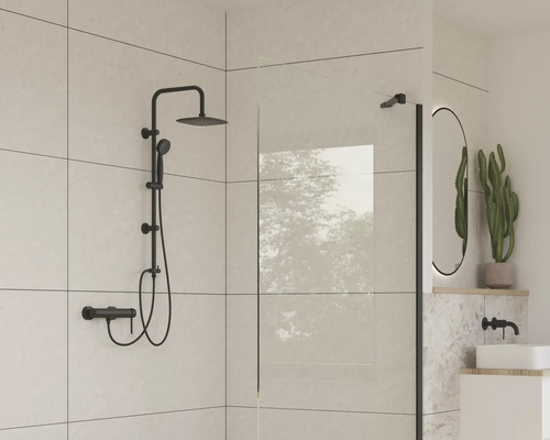 Modernt badrum med svart duschset, duschvägg och oval spegel