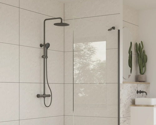 Badrum med duscharmatur och duschvägg