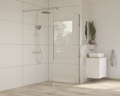 Modernt badrum med duschvägg, armaturer och tvättställ