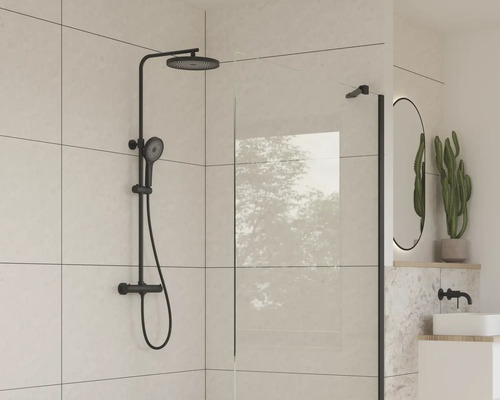 Badrum med svart duschset och duschvägg