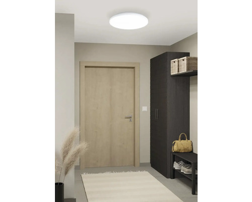 Hall med takspottar, dörr, skåp och skohylla för en organiserad entré.