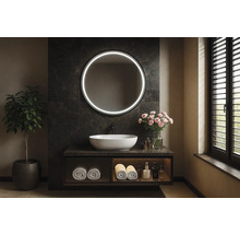 Badrum med rund spegel med belysning, handfat och växt