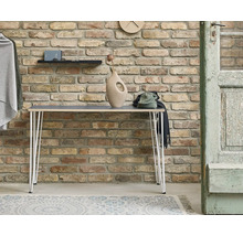 Scen med konsolbord, dekorationer och tegelvägg i bakgrunden