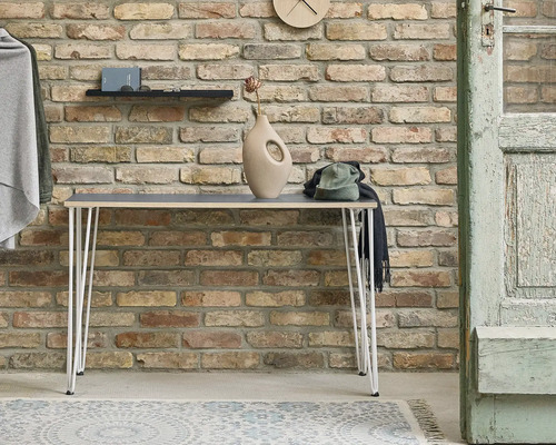 Scen med konsolbord, dekorationer och tegelvägg i bakgrunden