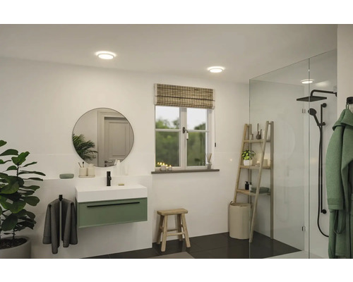 Ljust badrum med tvättställ, spegel, fönster och dusch