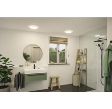 Badrum med handfat, spegel, fönster och dusch för en ljus och modern atmosfär