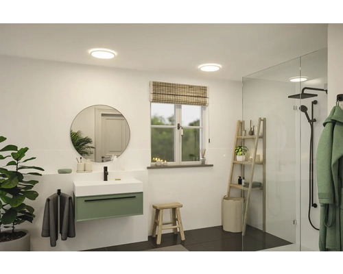 Badrum med handfat, spegel, fönster och dusch för en ljus och modern atmosfär