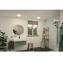 Ljust badrum med handfat, spegel, fönster och dusch