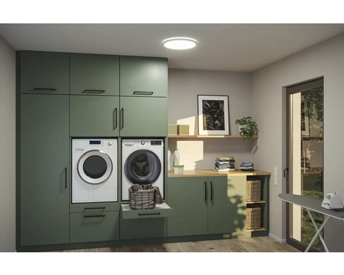 Tvättstuga med tvättmaskin, torktumlare, skåp och hyllor för ett organiserat utrymme