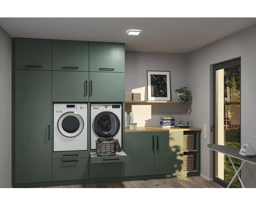 Tvättstuga med tvättmaskin, torktumlare, skåp och hyllor för organiserad tvättvård
