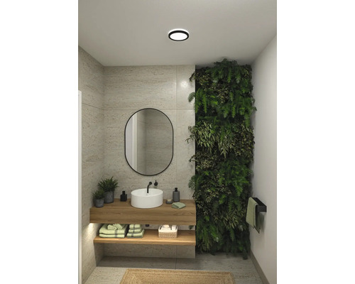 Badrum med handfat, spegel, växtvägg och trähyllor