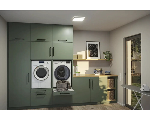 Ljust tvättrum med tvättmaskin, torktumlare och förvaringsskåp