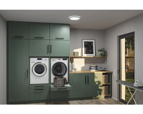 Ljust tvättrum med gröna skåp och tvättmaskin