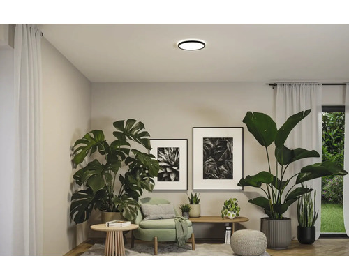 Vardagsrum med krukväxter, dekoration och en rund taklampa