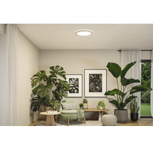 Vardagsrum med krukväxter, taklampa och dekorativa element för en ljus och vänlig atmosfär.