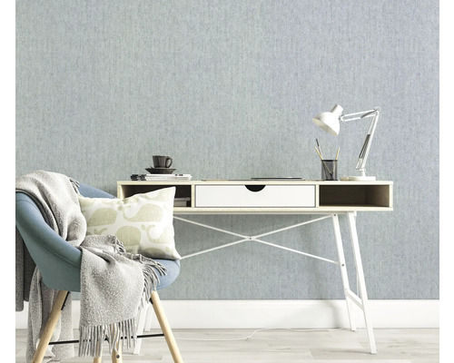 Ljust arbetsrum med skrivbord, stol och lampa mot en strukturerad tapet