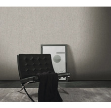 Vardagsrum med en grå strukturtapet, en svart fåtölj och en inramad bild