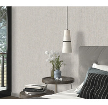 Sovrum med mönstrad tapet, sängbord och säng