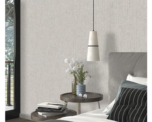 Sovrum med mönstrad tapet, sängbord och säng