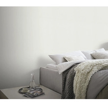 Ljust sovrum med säng, filtar och sidobord