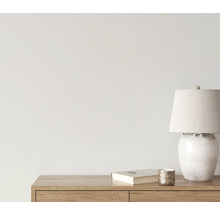 Dekorativ scen med bordslampa, bok och ljusstake på en trämöbel