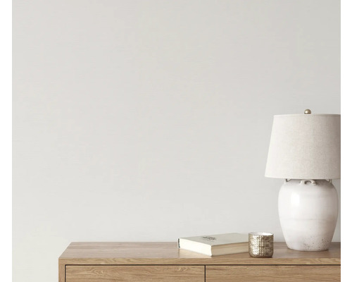 Dekorativ scen med bordslampa, bok och ljusstake på en trämöbel