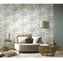 Vardagsrum med blommönstrad tapet, fåtölj och sidobord