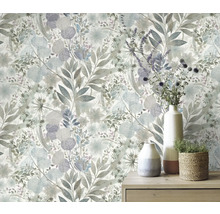 Vägg med blommig tapet och bord med vaser