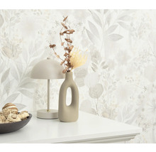 Dekorativ scen med blommig tapet, lampa, vas och skål på en byrå