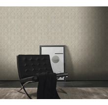 Vardagsrum med mönstrad tapet, fåtölj och tavla