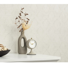 Dekorativt stilleben med bordsklocka, vas och geometrisk tapet