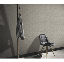 Miljöbild med mönstrad tapet, klädhängare och stol