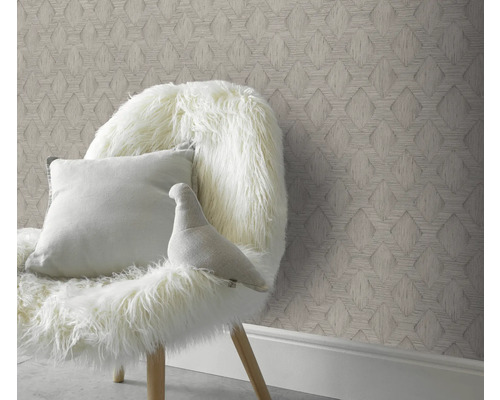 Dekorativt rum med mönstrad tapet och stol med kudde och dekorativ figur