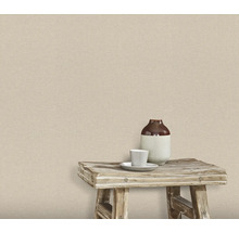 Vägg med textil tapet, på vilken det finns en pall med en vas och en kopp