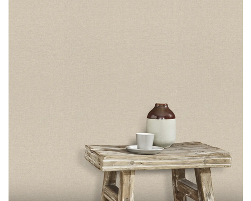 Vägg med textil tapet, på vilken det finns en pall med en vas och en kopp