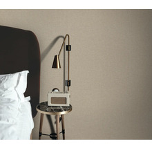 Sovrumsscen med textiltapet, sängbord och lampa