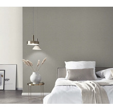 Sovrum med säng, nattduksbord, lampa och grå tapet