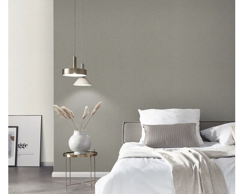 Sovrum med säng, nattduksbord, lampa och grå tapet