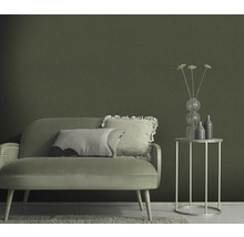 Vardagsrum med soffa, sidobord och grön väggtapet