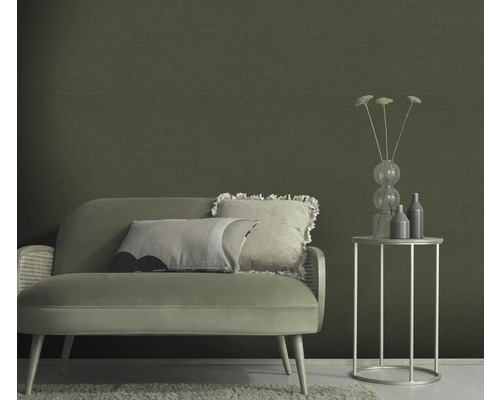 Vardagsrum med soffa, sidobord och grön väggtapet