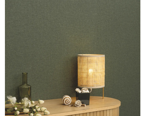 Närbild av en grön textiltapet med bordslampa och dekoration